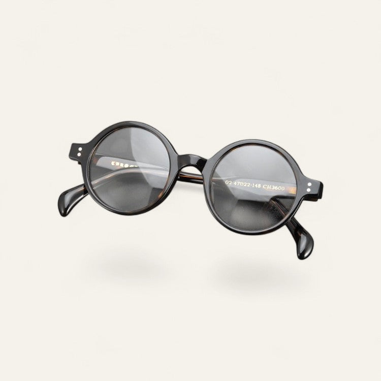 Driftward round retro blue light blocking glasses in a black acetate frame with clear lenses.